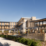 The outdoor courtyard of The Livelle features a modern building with a pool, seating areas, trees, and large windows under a clear blue sky.